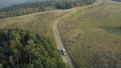 Aerial-following-truck-on-remote-dirt-road-Saskatchewan,-Canada