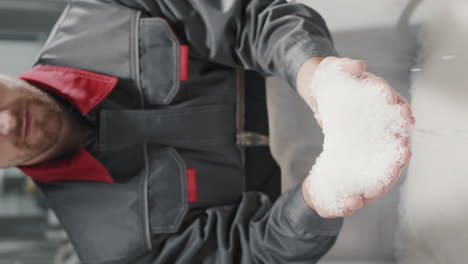 workman with handful of polypropylene granules