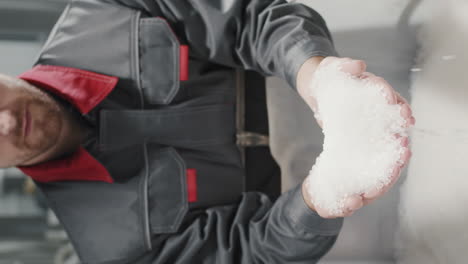 trabajador con un puñado de gránulos de polipropileno