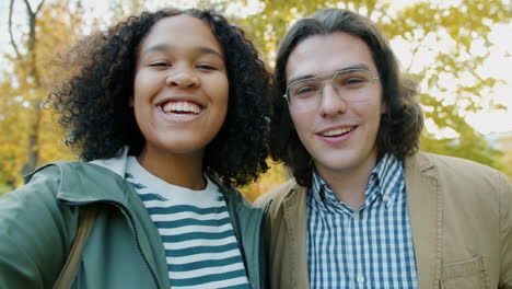 happy couple taking a selfie in autumn park