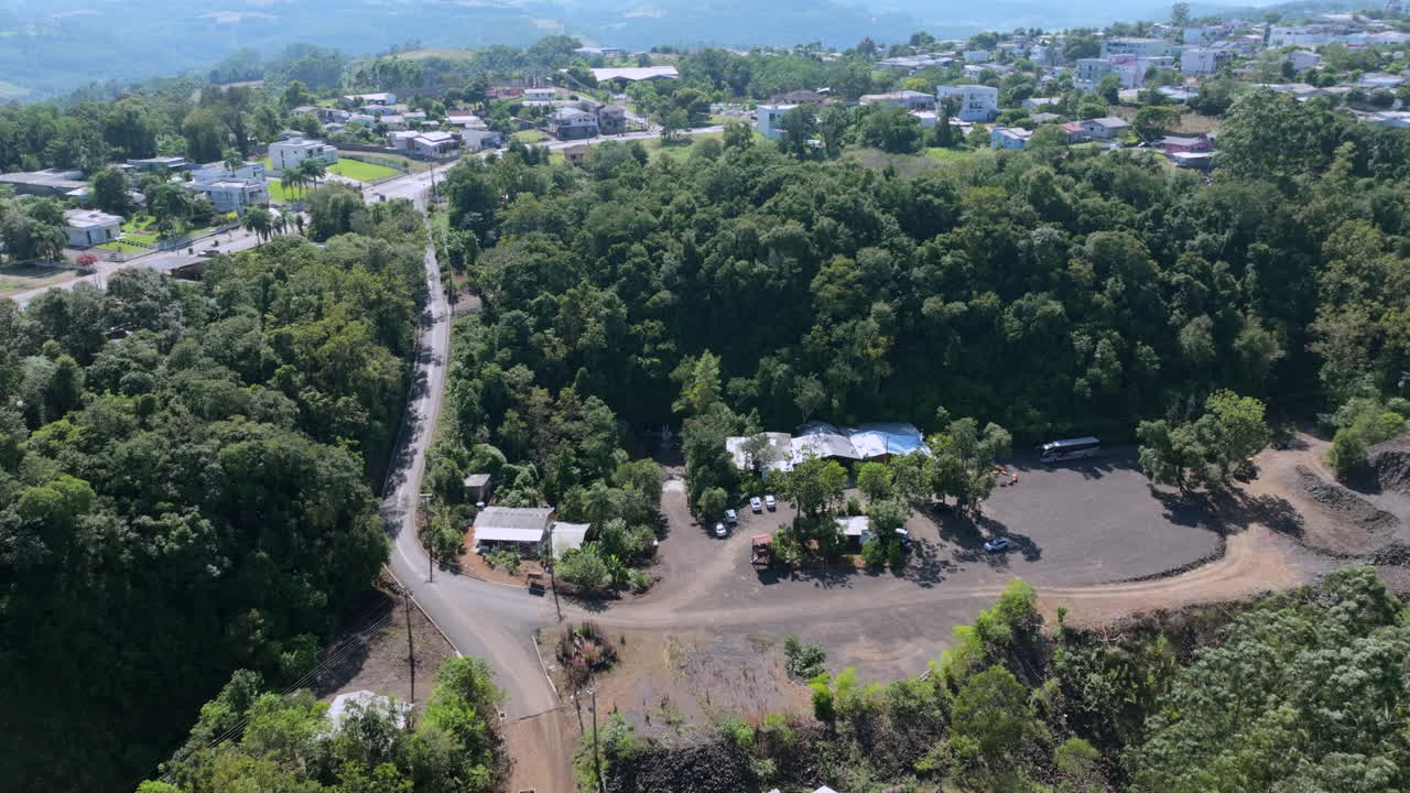Veduta aerea della collina di una miniera di ametista che mostra l'area di estrazione boscosa, la strada di accesso e la periferia della città nel Brasile meridionale.