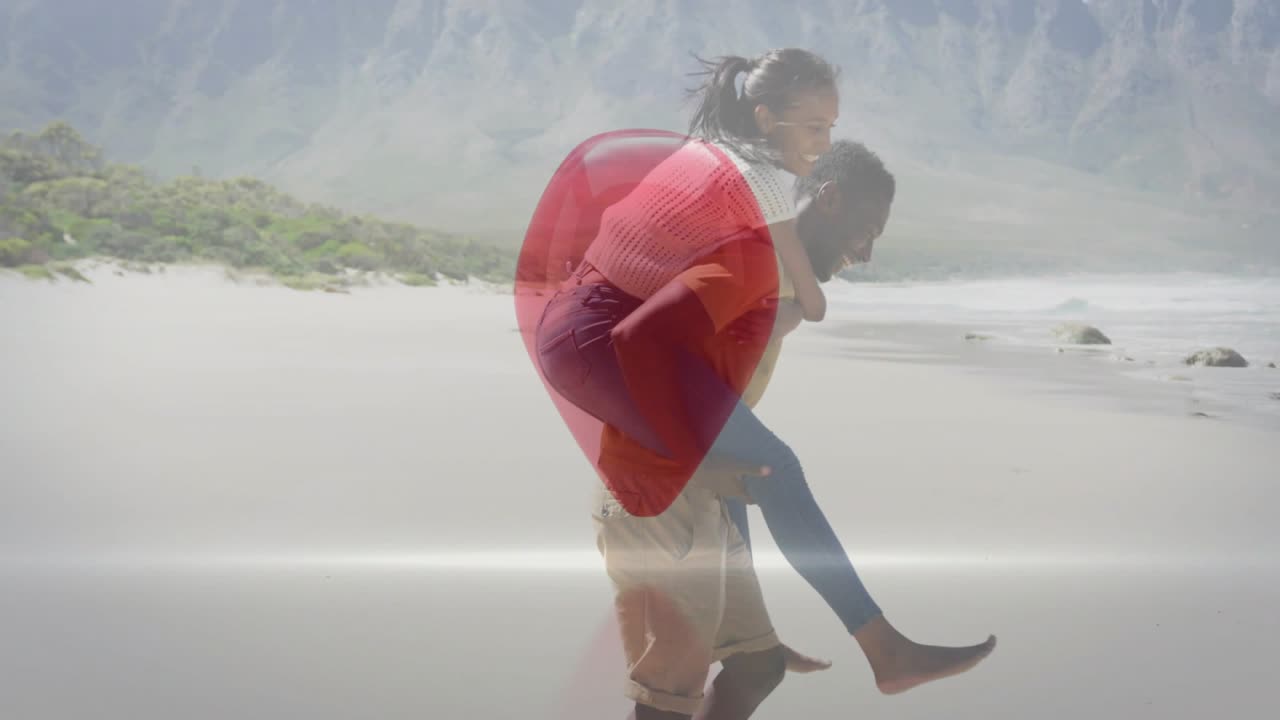 Mujer corriendo hacia un hombre, iniciando un paseo a cuestas para un anuncio, corazón rojo sobre la pareja con reflejo en la arena