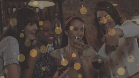 animation of glowing yellow lights over smiling female friends at party taking selfies
