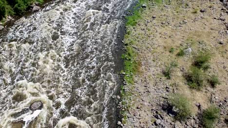 aerial drone tilting up from a rapid river in a canyon in mexico