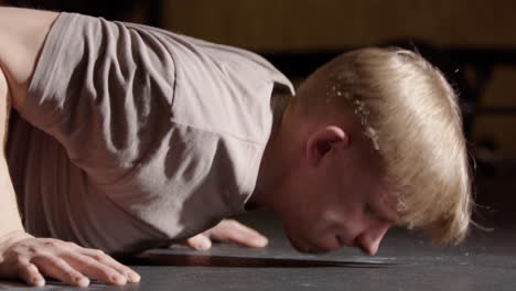 Male-Swedish-athlete-do-strict-push-ups-in-gym,-low-angle-side-closeup