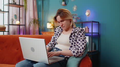 Thoughtful-young-woman-freelancer-got-an-idea-and-typing-on-laptop-netbook-celebrating-victory