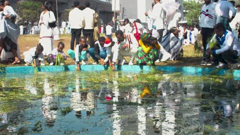 oromo ethiopians celebrating irreecha 2024 by performing a water ritual with reflections