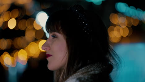 Cinematic-Close-up-of-beautiful-Woman's-Face-Profile-surrounded-by-colourful-Christmas-Lights-bokeh