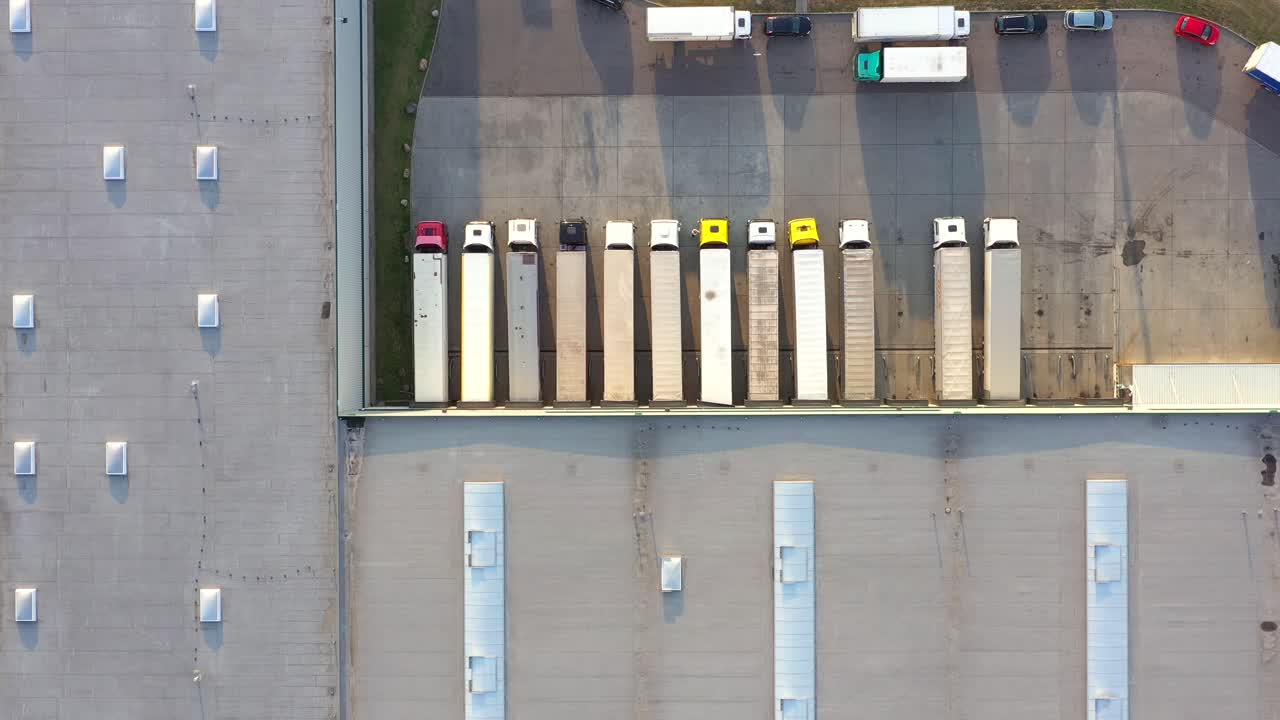 semirremolque con remolque de carga viaja a lo largo de un estacionamiento de un almacén en el parque logístico
