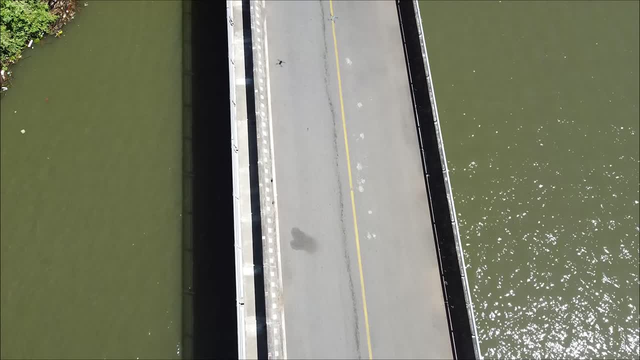 코스타리카의 저수지 위에 있는 긴 시멘트 다리, 큰 연못, 항공 영상