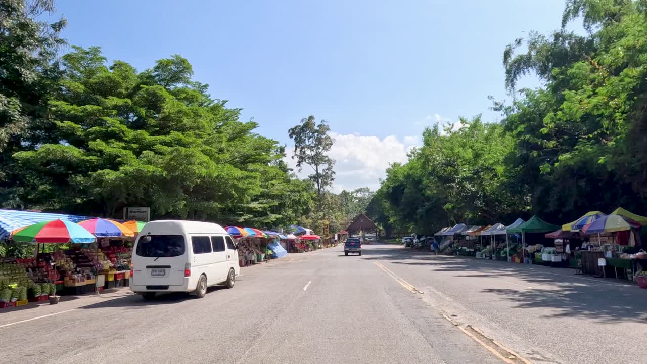 차량 들 이 빛 하늘 아래 공원 입구 에 접근 한다