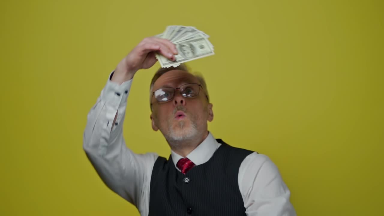 Glad forretningsmand isoleret. Mand står med dollars i hænderne på en isoleret baggrund.