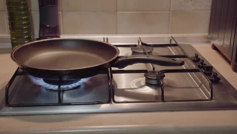 hand lighting gas stove, adjusting frying pan