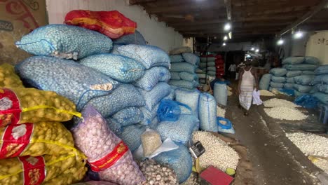 stacked sacks of garlic and ginger in market storehouse in bangladesh