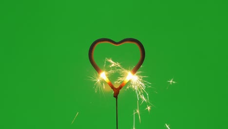 fuego de bengala en forma de corazón y chispas en fondo verde en 4k