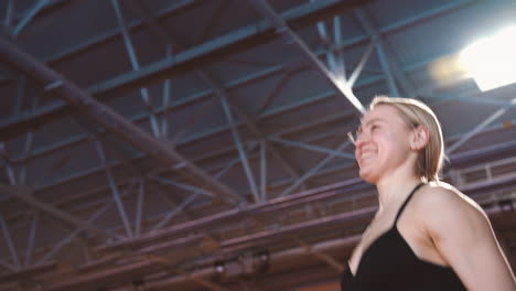 Happy-Blonde-Sportswoman-Jumping-And-Cheering-To-Celebrate-Victory-In-An-Indoor-Sport-Facility-1