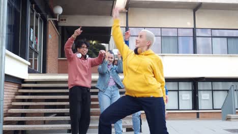 young women and men happily dancing on the university campus. students having fun