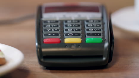 Human-hand-swipe-credit-card-in-pos-terminal.-Detail-of-card-terminal-payment