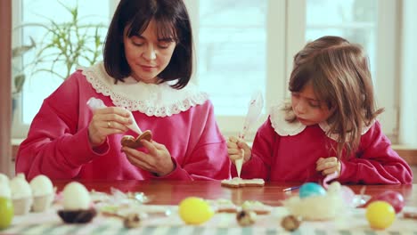 mother and daughter decorating easter cookies