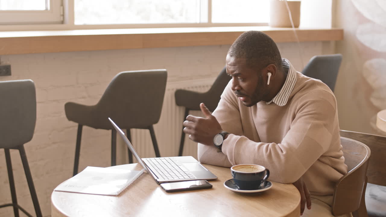 Afro American Businessman Video Conferencing on Laptop in Cafe