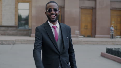 business man in black suit smiling outside
