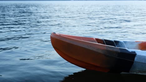 an empty boat floats on a tranquil lake.