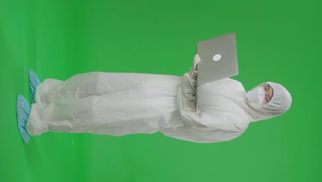 Person in Protective Gear with Laptop on Green Screen