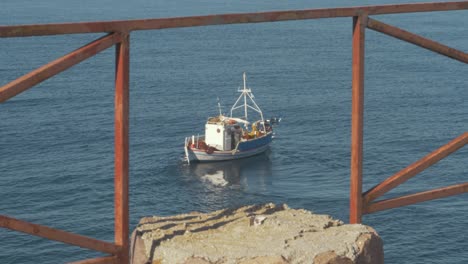 greek fishing boat through railings