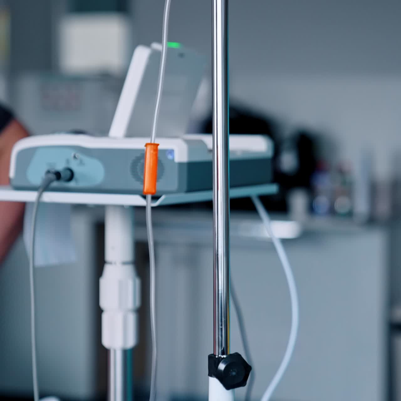Caucasian nurse's hand sets the drop counter. Hospital equipment arranged for work. Blurred backdrop