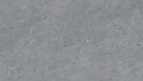 long raw white rice rotating in a slow motion, main meal of asia people