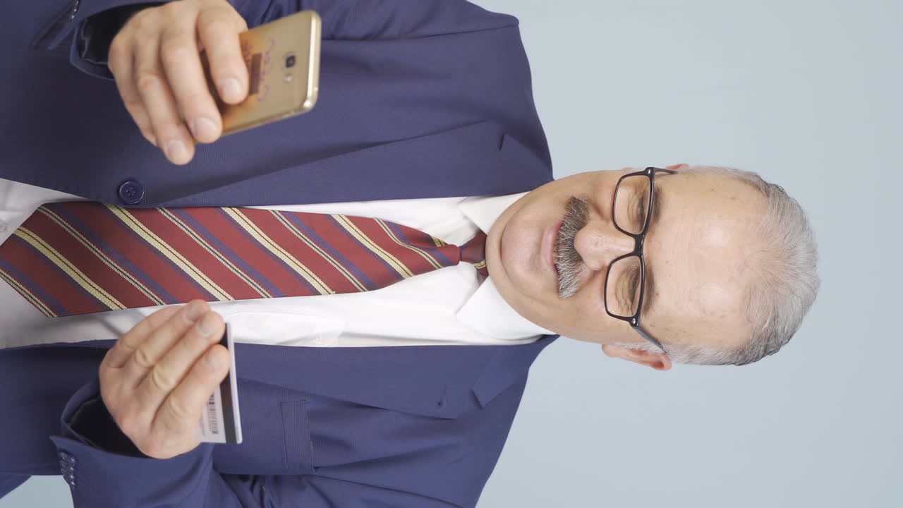 신용카드로 전화로 쇼핑하는  ⁇ 은 사업가의 수직 비디오.