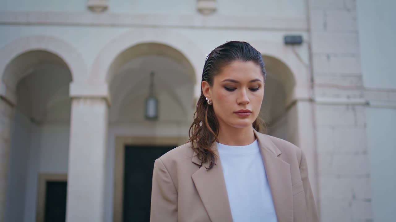 평온한 사업가 여자가 걸어가는 도시 황혼 가까이. 심각한 여자가 혼자 산책