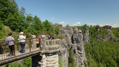 visitors on a bridge overlooking sandstone rock formations