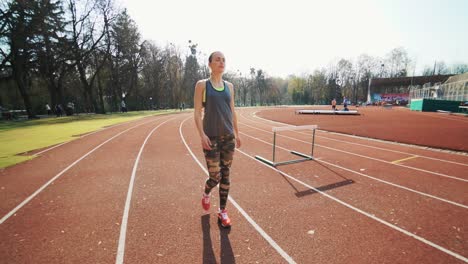 young fit woman working out by running on urban stadium track. runner on the running track.
