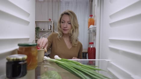 woman looking inside the fridge at home