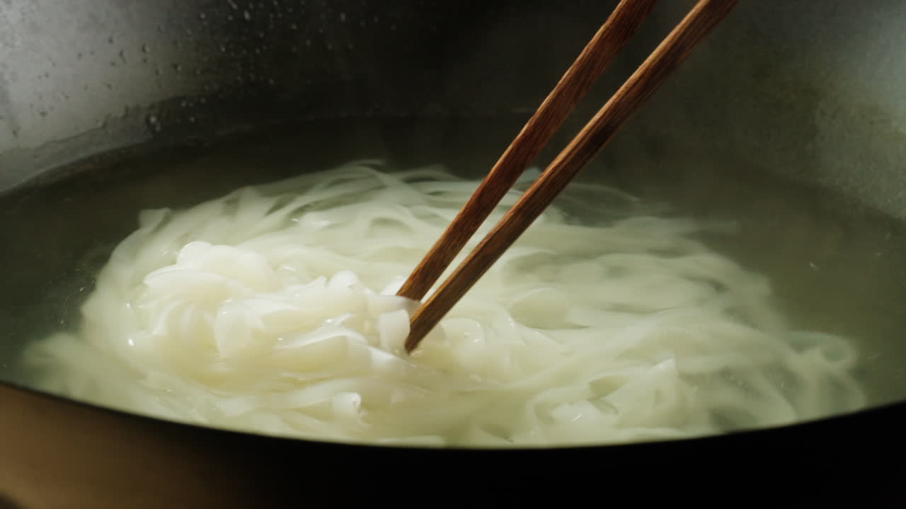 Cooking Noodles in a Pot with Chopsticks