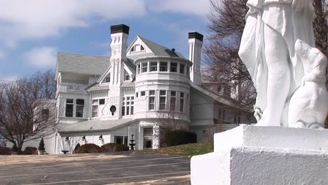 The-Camera-Focuses-On-A-Giant-White-Ornate-Mansion-Designed-With-Many-Different-Winds-And-Architectural-Elements