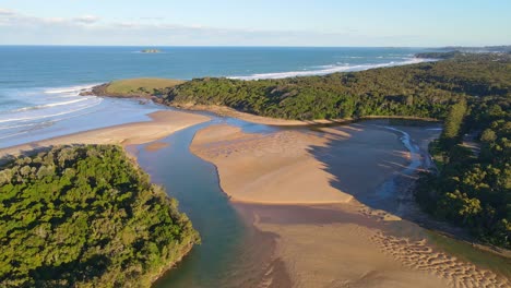 arroyo moonee con arena marrón y aguas poco profundas - estuario en la playa moonee en nsw, australia