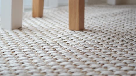 close-up view of a woven rug with wooden chair legs