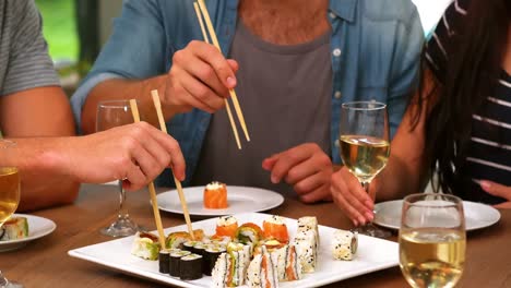 amigos felices comiendo sushi