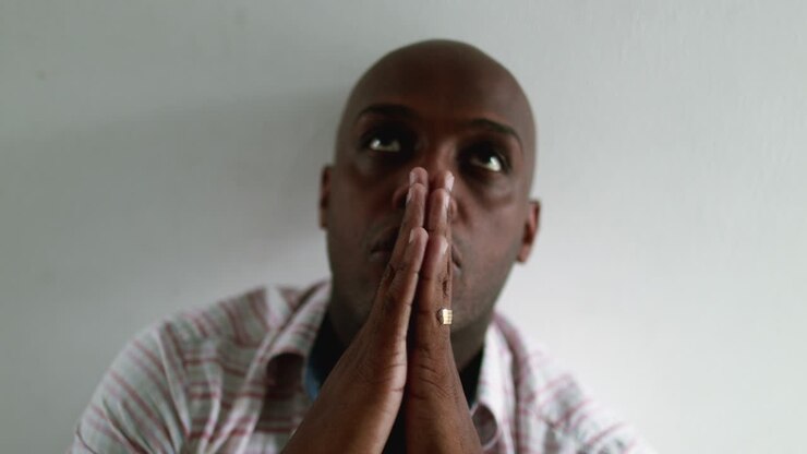 Uomo africano religioso che prega Dio