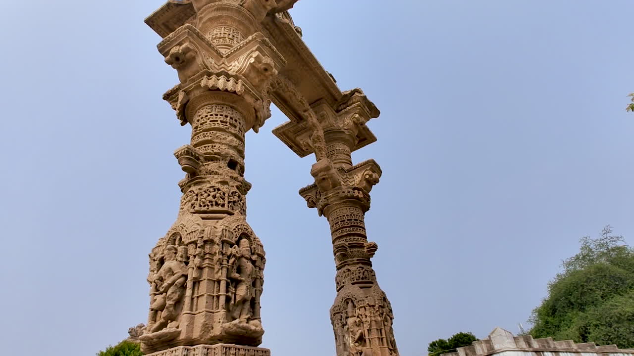 Narsinh Maheta Ni Chowri Vadnagar Gujarat Intia, kaiverretut kivipilarit ja matalasta kulmasta otettu kaari, muinainen hindumonumenttiarkkitehtuuri, yksityiskohtainen käsityötaito, kulttuuriperintökohde, ulkona sijaitseva uskonnollinen paikka
