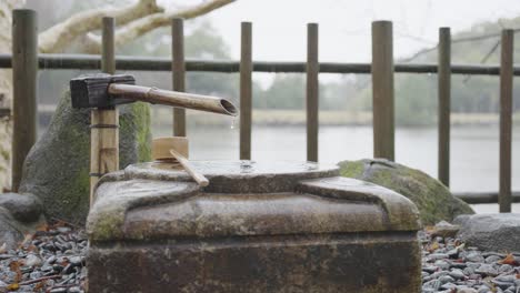 Bamboo-fountain-and-hand-washing-Chozuya-in-the-rain,-Nara,-Japan