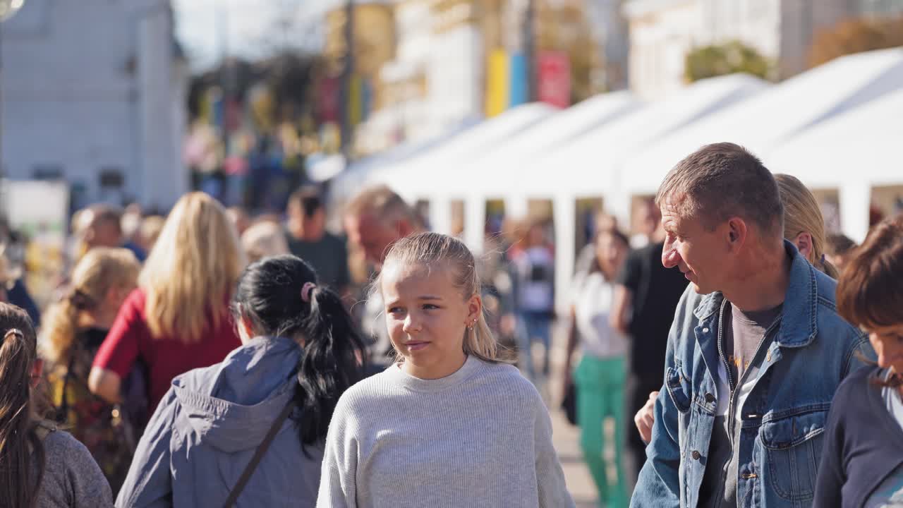 Family walking on the blur city background. People in the busy city street. Crowds of people having rest in the center of the city.