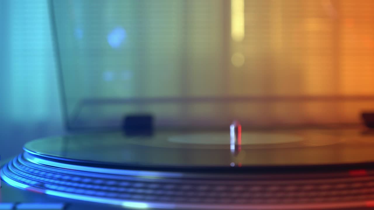 비닐 플레이어 턴테이블: 회전하는 비닐 판의 조각, 바늘이 있는 스타일러스 클로즈업, 소녀의 손이 플레이트에서 스타일러스를 제거합니다.