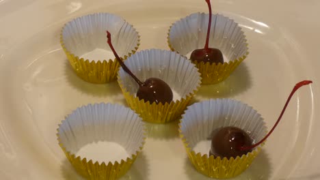 chocolate-dipped cherries are placed in gold cups.