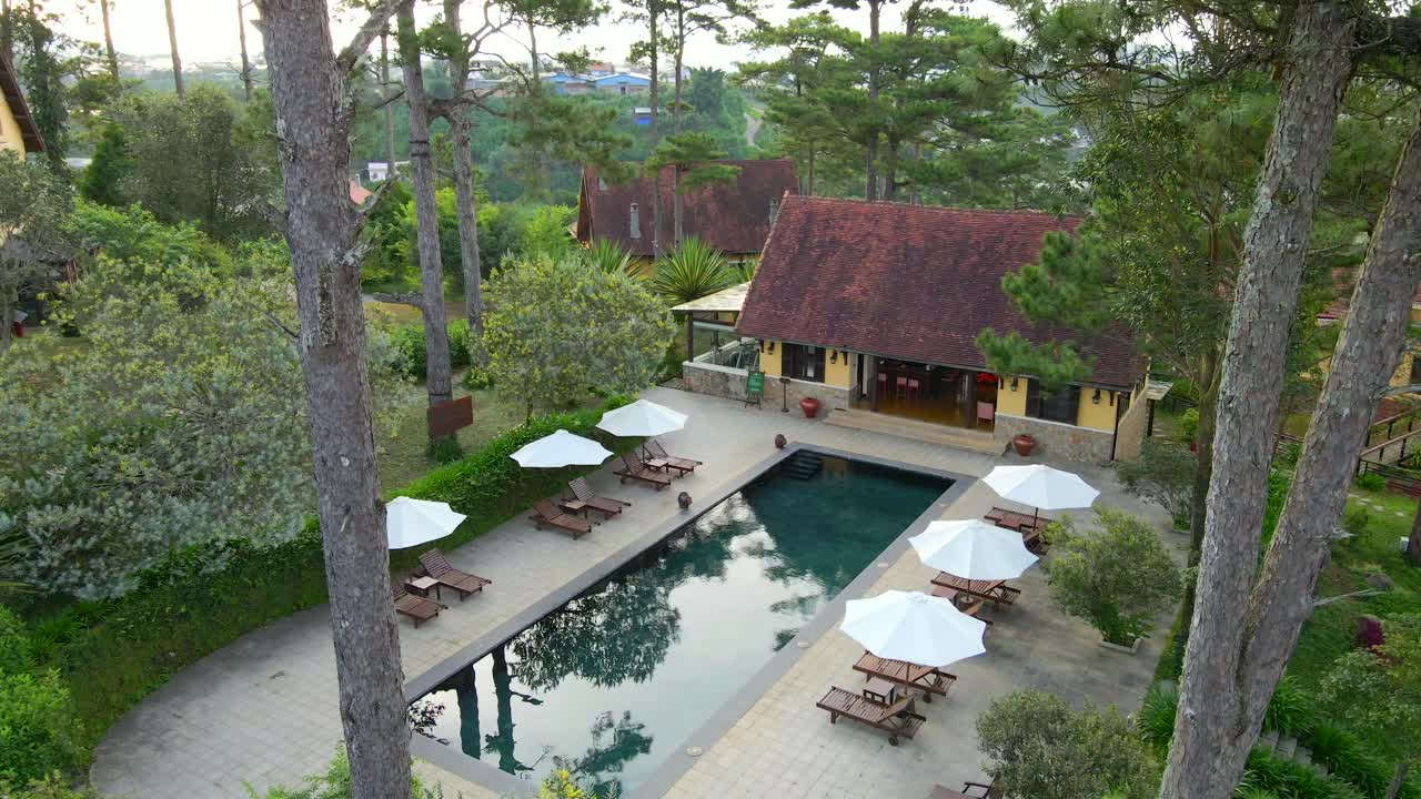 햇빛 아래 아름다운 수영장 위를 날고 있는 공중 드론은 hill_dalat vietnam_4k 24fps의 리조트 풍경을 보여줍니다.