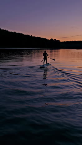 paddleboarding at sunset on a lake