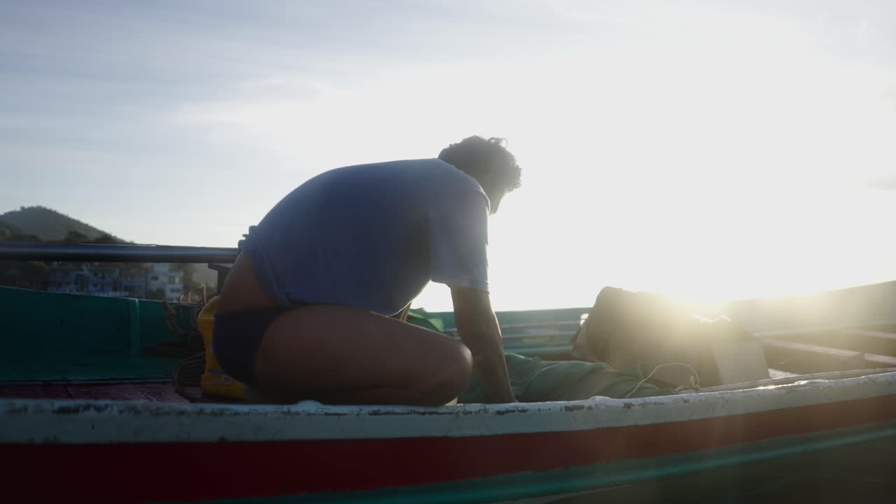 A person on a boat during sunrise or sunset