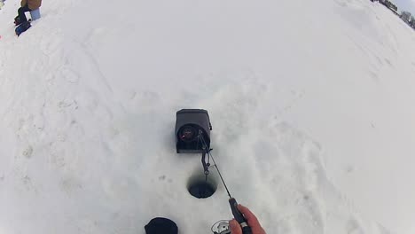 Un-Hombre-Que-Emplea-Una-Luz-Intermitente-Mientras-Pesca-En-El-Hielo:-Toma-De-ángulo-Alto